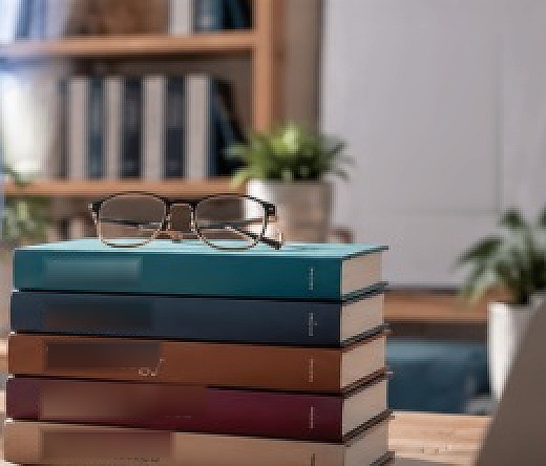 Reading glasses on a stack of science, medicine, technology, social sciences and humanities journals